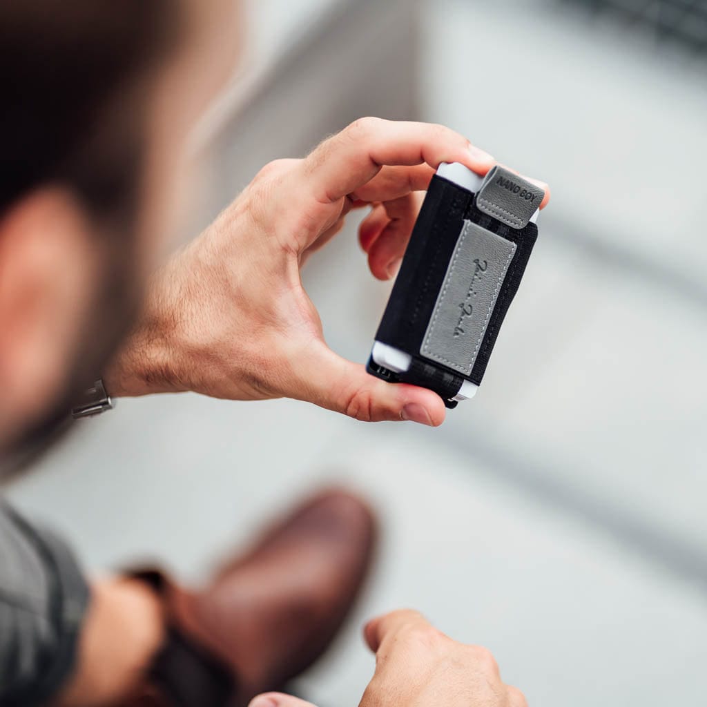 Person holding a small card holder from jaimie jacobs with coin pocket with a blurred background